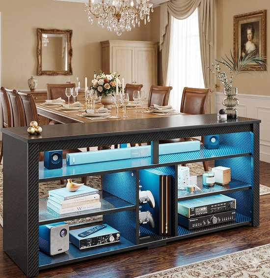 Zwart tv-meubel met koolstofvezeldesign en blauwe LED-verlichting. Open vakken met verstelbare planken, gevuld met o.a. speakers, gameconsoles en audioapparatuur.