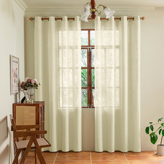 Crème inbetween gordijnen met ringen in een woonkamer.