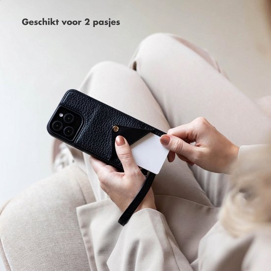 Model plaatst kaarten in de pashouder van de zwarte pebbled lederen telefoonhoes.
