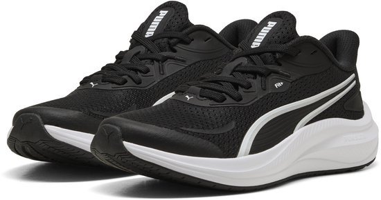 Baskets PUMA noires avec semelle blanche et rayures argentées.