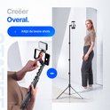 Een vrouw staat naast een lang uitgeschoven Studio ME statief, een telefoon met LED-lampje is bevestigd.