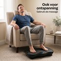Man zit ontspannen in een stoel met zijn voeten op een Fithlon trilplaat.