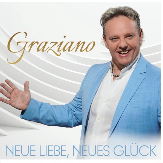 Graziano draagt een lichtblauwe blazer over een wit overhemd. De tekst 'Graziano' en 'NEUE LIEBE, NEUES GLÜCK' staan op de afbeelding.