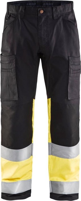 Pantalon de travail noir avec panneaux jaunes et larges bandes réfléchissantes sur le mollet.