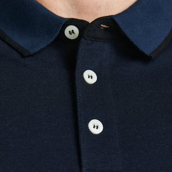 Donkerblauw poloshirt met kraag, knoopjes en contrasterende rand.