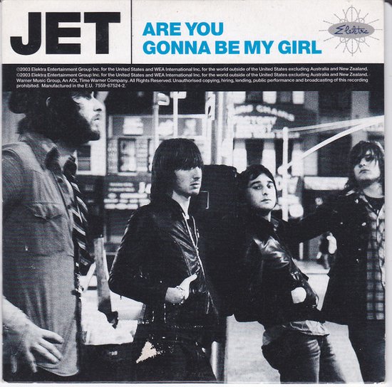 Vier mannen staan op een straat, met bovenaan de tekst "JET ARE YOU GONNA BE MY GIRL".