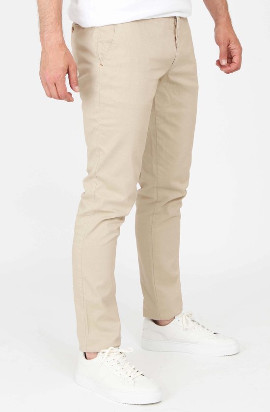 Rechterzijkant van een mannen chino in lichtbeige, gedragen met witte sneakers.