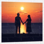 Muursticker - Silhouet van Koppel Hand in Hand bij de Zee tijdens Zonsondergang - 80x80 cm Foto op Muursticker