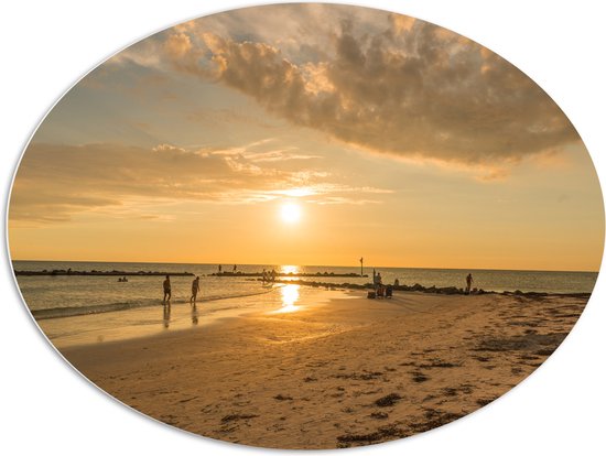 PVC Schuimplaat Ovaal - Personen - Avondzon - Zee - Strand - Zand - Water - Wolken - 108x81 cm Foto op Ovaal (Met Ophangsysteem)