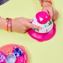 Hands van een kind maken een armband met de Pop Style Bracelet Maker en felgekleurde kralen.
