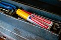 Twee Edding 800 markers, één geel, één rood, in een gereedschapskist.