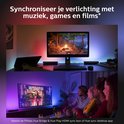 Synchronisez votre éclairage avec la musique, les jeux et les films. L'éclairage colore le mur en rouge, violet et bleu.