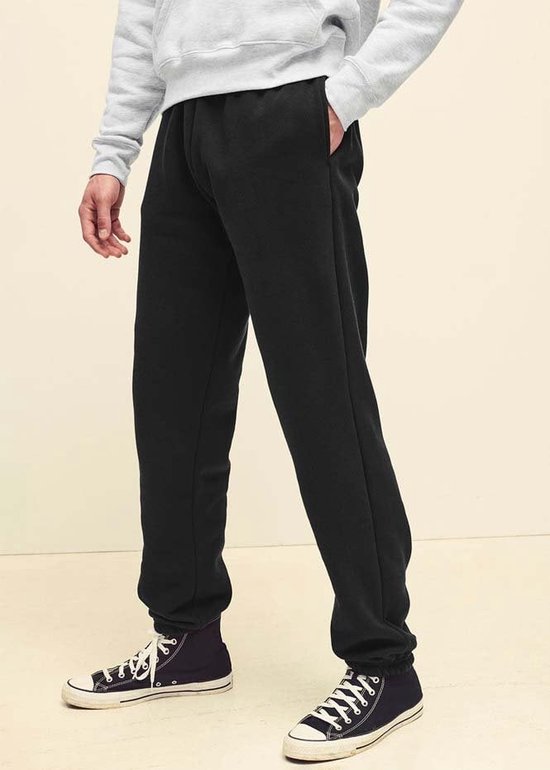 Zwarte Fruit of the Loom joggingbroek met open zoom, gedragen door een man met een grijze hoodie en zwarte sneakers.