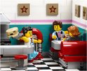 LEGO minifiguren in een Diner met rood-wit geblokte vloer en sterren aan de muur. Een serveerster rolt een burger aan.