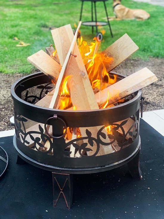 Zwarte Gardebruk vuurkorf met brandend hout, op een zwart kleed in de tuin.