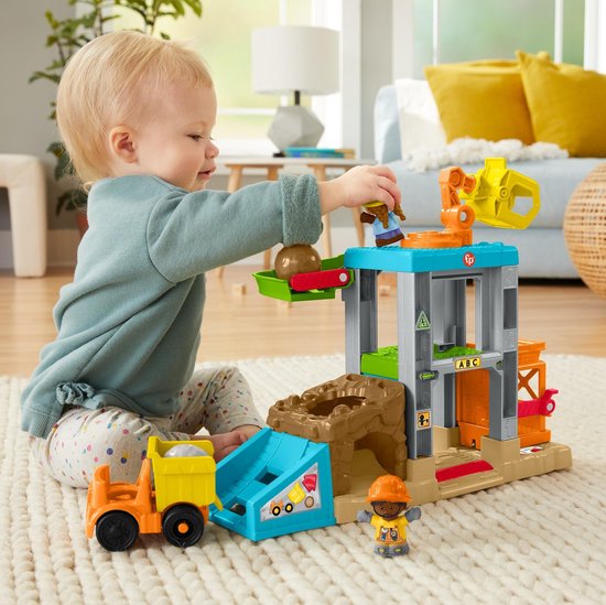 Kind speelt met de Little People bouwplaats-speelset met kiepwagen en rotsen.