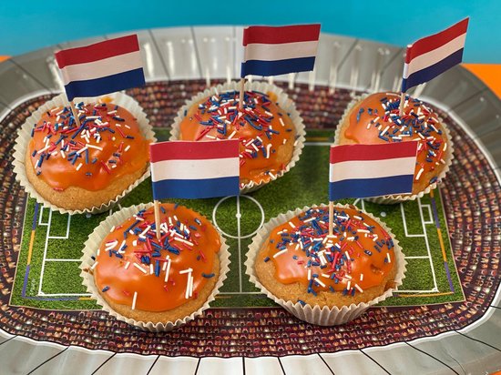 Vijf oranje cupcakes met Nederlandse vlaggetjes op een stadion-bord.