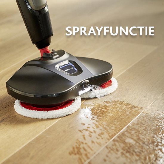 Zwarte elektrische vloermop met twee witte pads sproeit water op een houten vloer. Tekst "SPRAYFUNCTIE".
