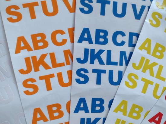 Stickers met de letters ABC, JKL, STU in oranje en blauw, en JKL, STU in geel.