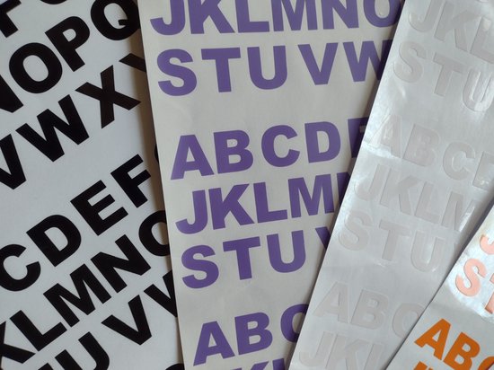 Stickers met de letters ABC, JKL, STU in paars en zwart, en ABC, JKL, STU in wit en oranje.