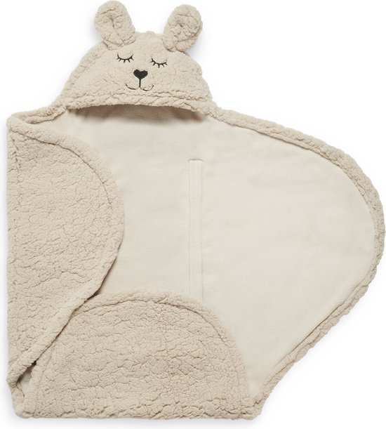 Beige baby wikkeldeken met konijnenoren, geborduurde ogen en neus, gebreide textuur.