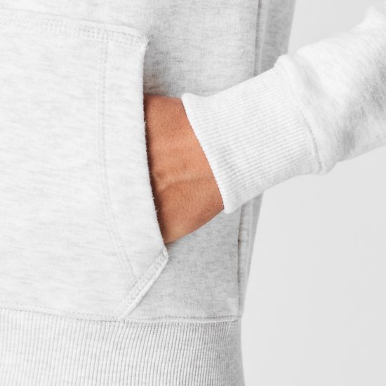 Close-up van een dames hoodie met een open rits en een hand in de kangoeroezak. De stof is lichtgrijs gemêleerd.