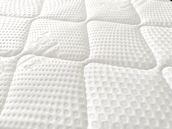 Detail van het witte matrasoppervlak met verschillende texturen en de tekst 'Feels so good'.