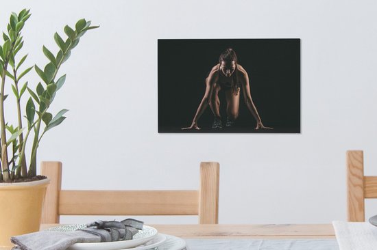 Canvas Schilderij Vrouwelijk sporter op zwarte achtergrond - 30x20 cm - Wanddecoratie - OneMillionCanvasses