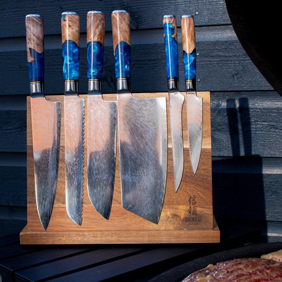 Zes koksmessen met blauwe epoxy handvatten, staand in een houten magnetisch messenblok.