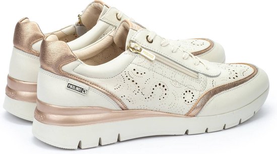 Deux sneakers Pikolinos en cuir écru perforé, accents dorés, fermeture éclair et lacets. Détails dorés métalliques sur le côté et le talon.