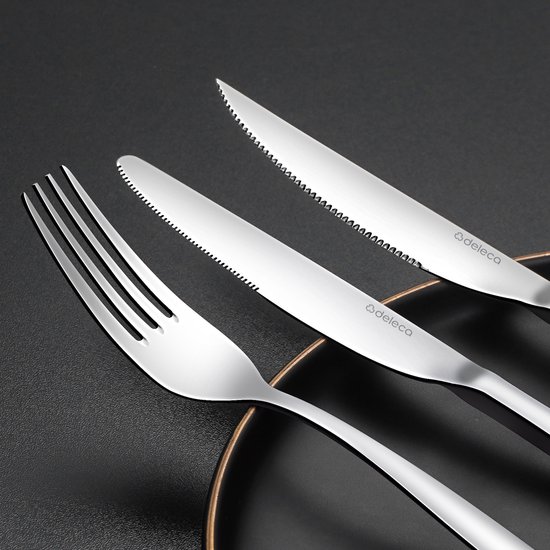 Set de couverts argentés avec couteau, couteau à beurre et fourchette sur une assiette noire.