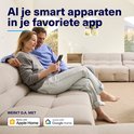 Man en vrouw zitten op een beige bank, kijkend naar een smartphone. Logo's voor Apple Home en Google Home.