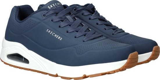 Baskets Skechers bleu marine inclinées avec semelles blanches et semelles extérieures couleur gomme.