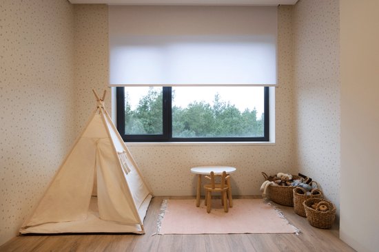 Lichtbeige kinderkamer met een witte rolgordijn, een tipi, een speeltafel en manden met speelgoed.