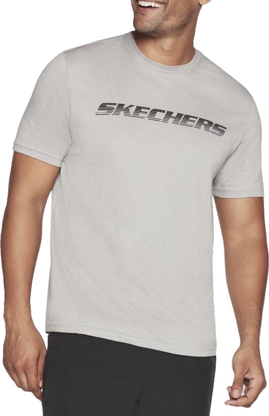 Man met grijze Skechers T-shirt met zwarte tekst.