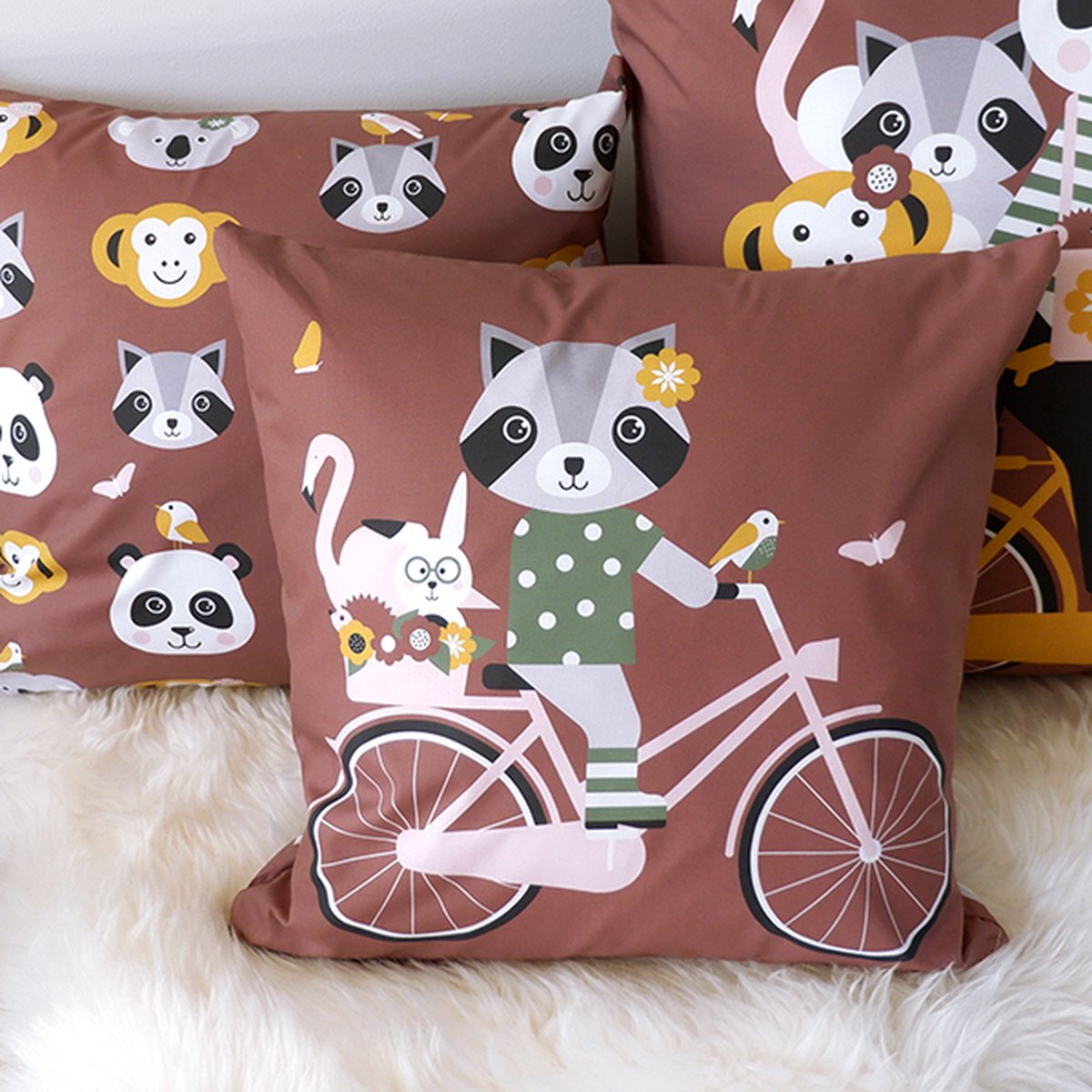 Sierkussen Wasbeer op de fiets 40x40 tweezijdig bruin met rits inclusief vulling voor kinderkamer