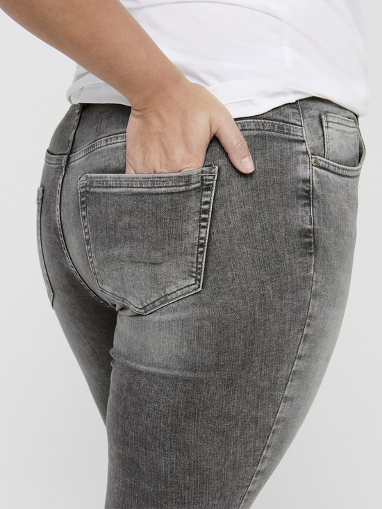 Achterkant van grijze skinny jeans met rafelende zoom.