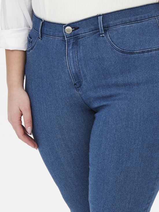 Blauwe skinny jeans, detail van de voorkant met knoop en ritssluiting.
