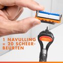Een hand die een Gillette Fusion 5 scheermesje vasthoudt, boven het scheerapparaat.