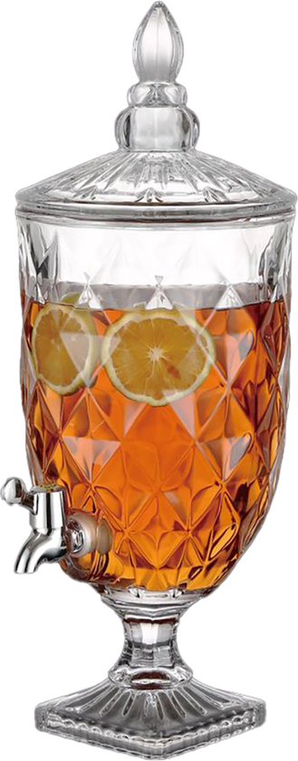 Distributeur de boissons en verre rempli de boisson orange et de rondelles de citron, avec motif facetté et robinet argenté.