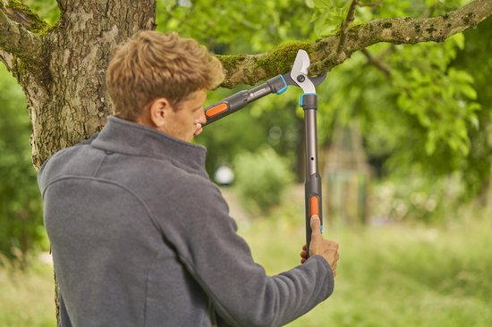 Man snoeit takken met een GARDENA Takkenschaar TeleCut Pro S met lange hendels.
