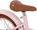 Bruin fietszadel met zilveren studs op roze fiets.