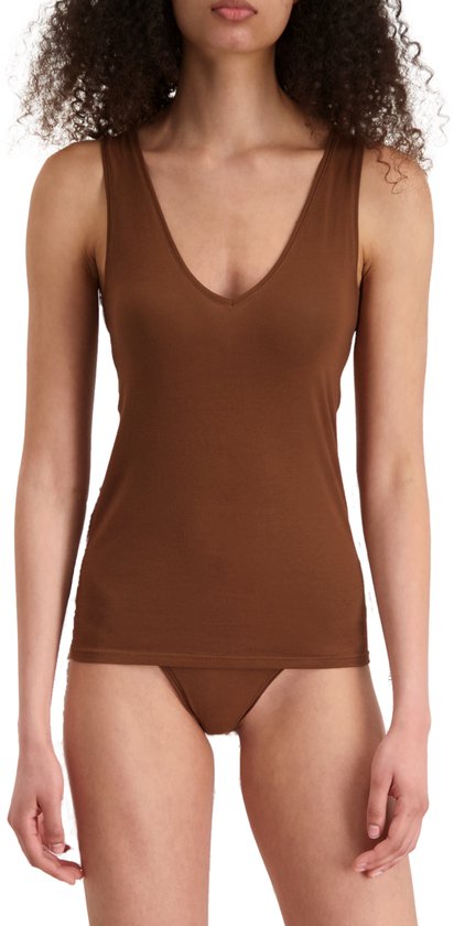 Vrouw met krullend bruin haar, die een bruin Noshirt tanktop met V-hals draagt.