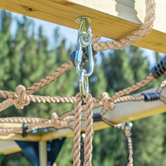 Detail van een karabijnhaak die een touw aan een houten balk bevestigt.