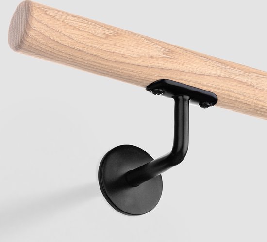 Houten trapleuning met een zwarte, gebogen houder met een plat zadel. De houder is aan de muur bevestigd.
