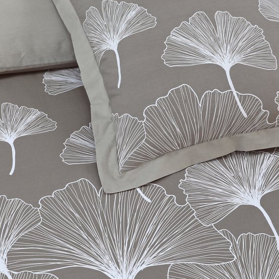 Close-up van een grijs dekbedovertrek met witte ginkgo bladeren en een beige rand.