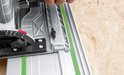 Detail van een Bosch invalzaagmachine op een geleiderail met groene stroken.