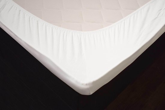 Wit hoeslaken met elastische randen op een matras met gewatteerd patroon.