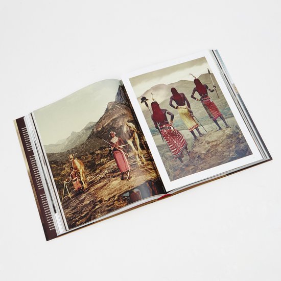 Open boek met foto's van traditioneel geklede personen met kamelen en wapens in een berglandschap.