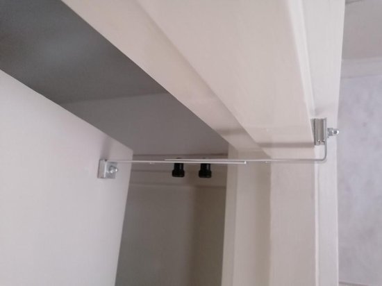 Sluitingsmechanisme met zwarte knoppen aan een witte deurpost.
